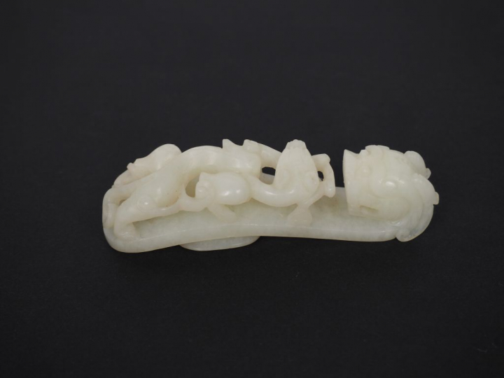 Ensemble de six fibules en jade blanc céladon décor de double dragon. 