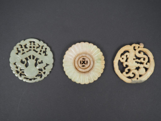 Vente aux enchères Lot comprenant : - un pendentif en jade céladon, à décor d'objets mobi