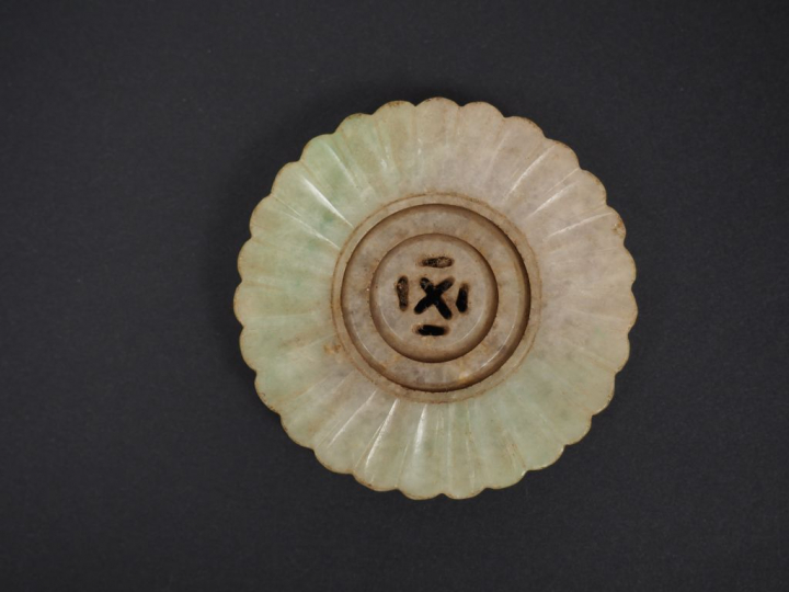 Lot comprenant : - un pendentif en jade céladon, à décor d'objets mobi