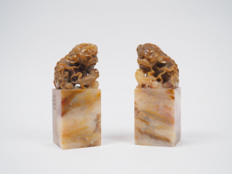 Vente aux enchères Deux sceaux en stéatite beige, les prises ornées de lions bouddhiques.