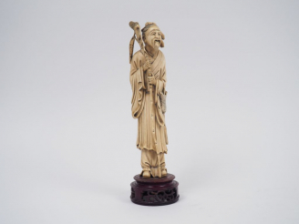 Vente aux enchères Statuette en ivoire représentant un pêcheur tenant un bambou auquel es