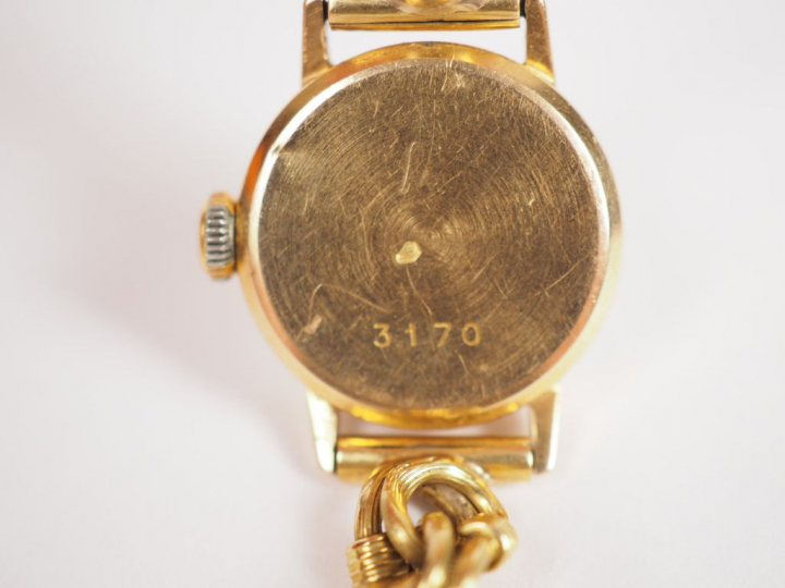 SUPER ASTRAL.  Montre de dame, boitier et bracelet en or jaune. Numéro