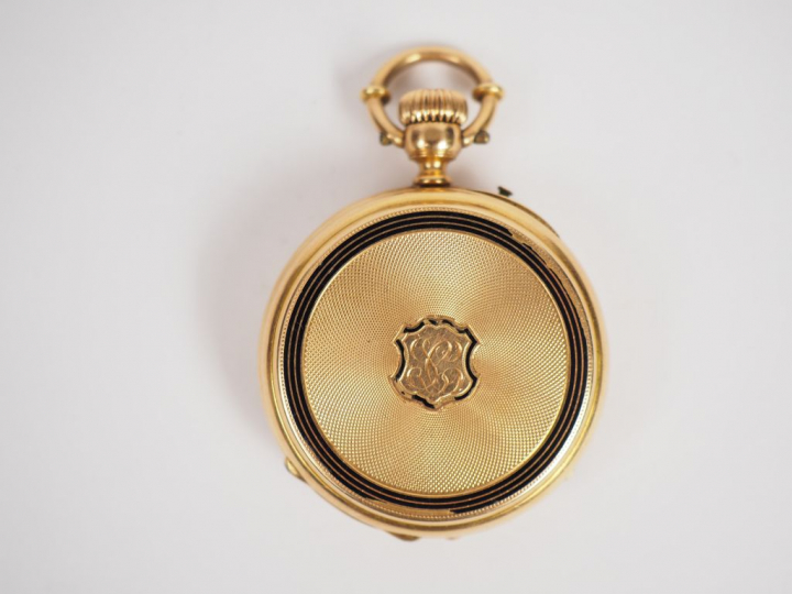 Montre de col en or jaune, à décor gravé et émaillé noir au revers d'u