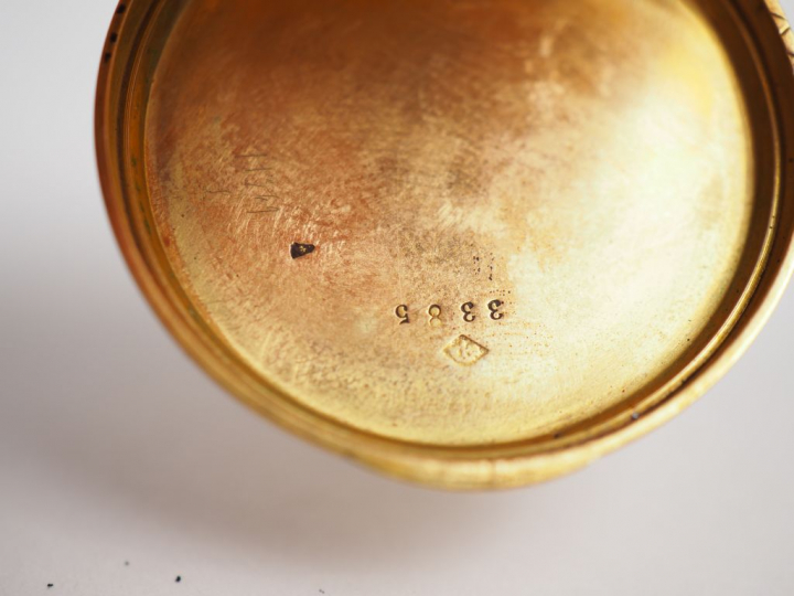 Montre de col en or jaune, à décor gravé et émaillé noir au revers d'u