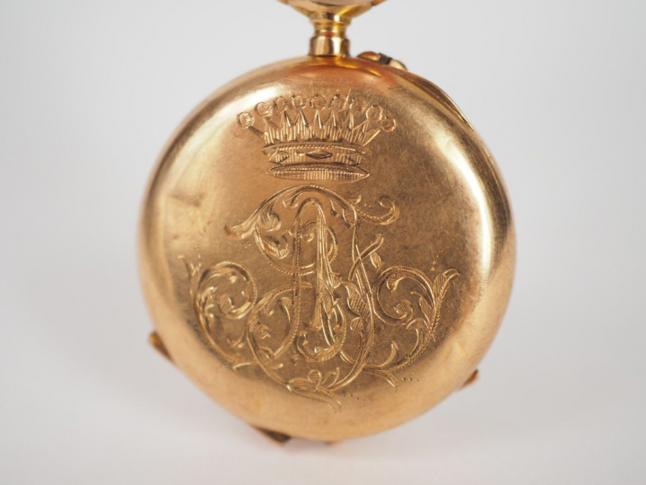 Montre de col en or jaune, à décor gravé de monogramme et d'une couron