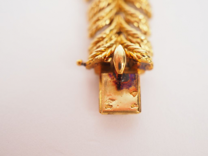 BOUCHERON, Paris.  Bracelet articulé en or jaune, orné d'une ligne de 