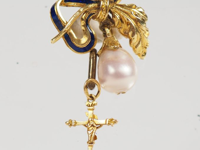 Pendentif en or jaune et émail bleu, à décor d'un nœud de ruban retena