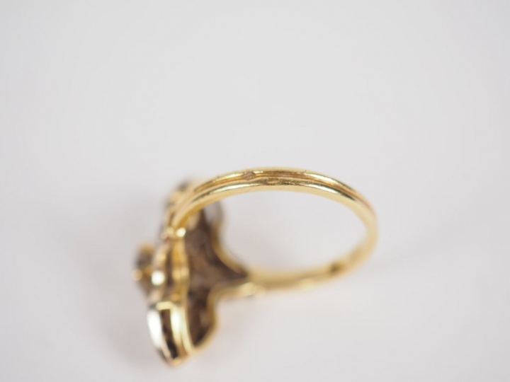 Bague marquise en or jaune, à décor de fleurs, ornée en son centré d'u