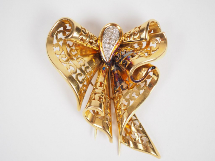 Broche en or jaune, en forme de ruban stylisé, à décor en son centre d