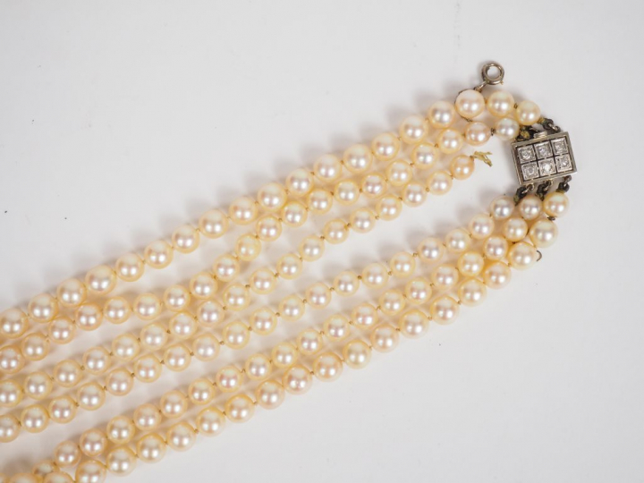 Collier de perles triple rangs.  Fermoir en or blanc orné de six petit