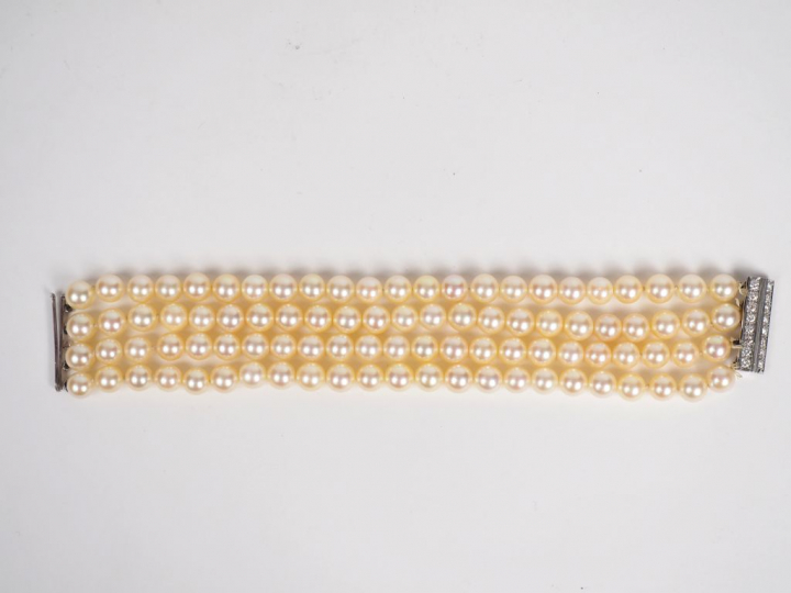 Bracelet quatre rangs de perles. Fermoir en or blanc, orné de deux lig