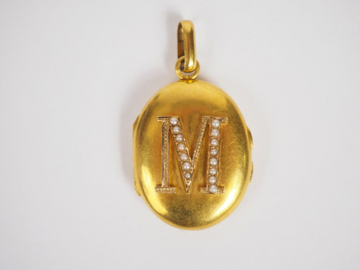 Pendentif porte-photo en or jaune, orné d'un M à décor de perles.  Poi