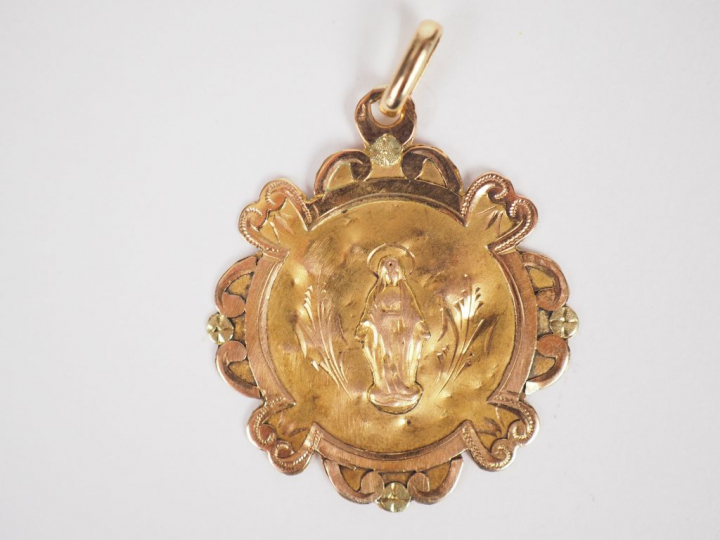 Médaille de baptême en or jaune à bord polylobé.  Monogrammée au rever