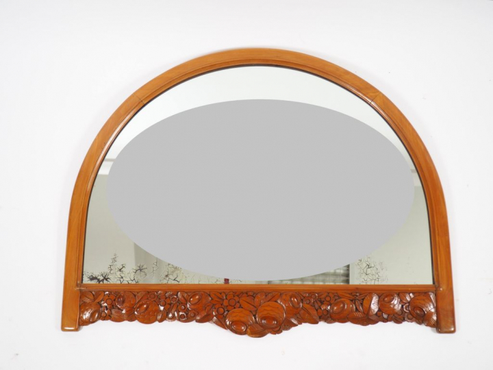 Léon JALLOT. Miroir en merisier mouluré et sculpté à décor de frise de