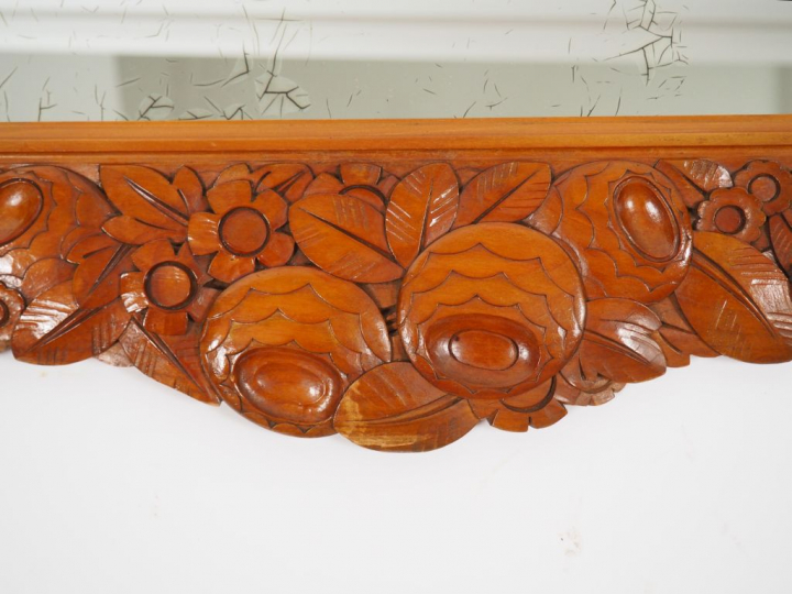 Léon JALLOT. Miroir en merisier mouluré et sculpté à décor de frise de