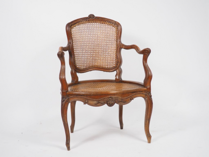 Fauteuil Louis XV en bois mouluré et sculpté à décor de fleurettes.