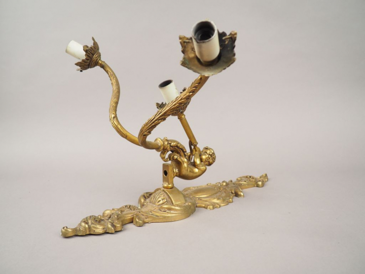 Suite de quatre appliques en bronze de style Louis XV, à décor d'amour