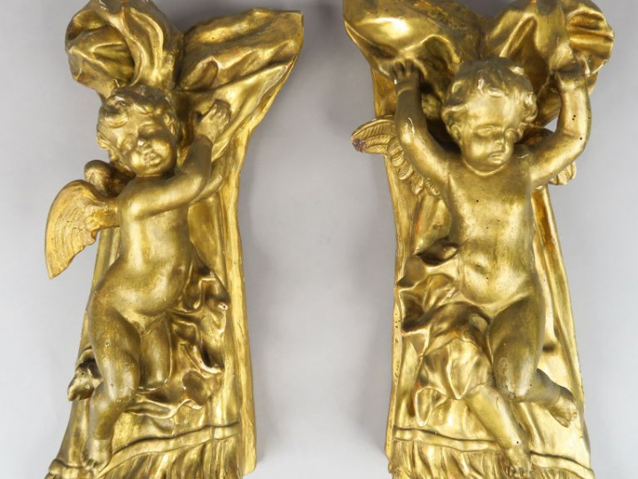 Paire d'anges XIXème en bois et stuc doré, se détachant sur fond de dr