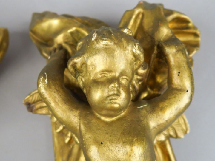 Paire d'anges XIXème en bois et stuc doré, se détachant sur fond de dr