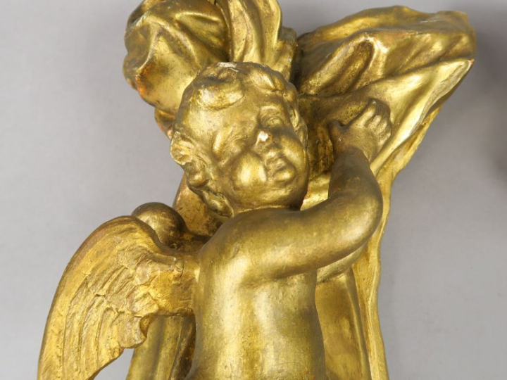 Paire d'anges XIXème en bois et stuc doré, se détachant sur fond de dr