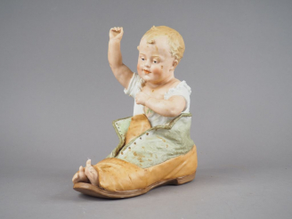 Vente aux enchères Grand sujet fin XIXème en biscuit polychrome "enfant dans une chaussur