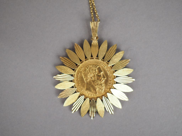 Pendentif en forme de fleur en or jaune, orné en son centre d'une pièc