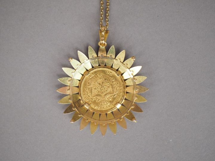 Pendentif en forme de fleur en or jaune, orné en son centre d'une pièc