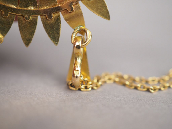 Pendentif en forme de fleur en or jaune, orné en son centre d'une pièc