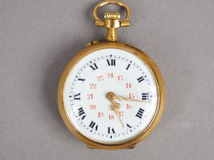 Montre de col en or jaune.  Le revers à décor de trophée d'instruments