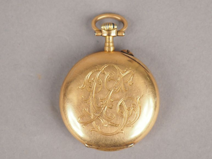 Montre de col en or jaune, cadran émaillé, chiffres arabes.  Le revers