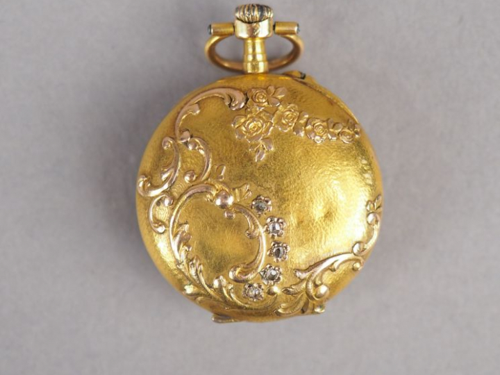 Montre de col en or jaune, cadran émaillé, chiffres arabes. Le revers 