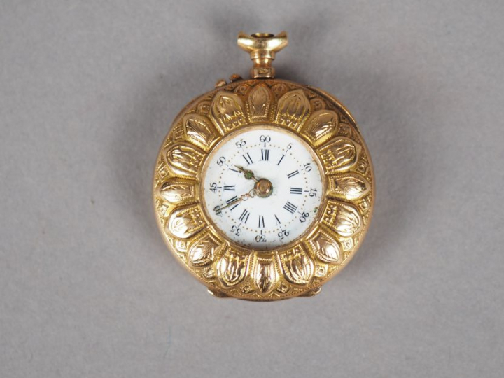 Montre de col en or jaune, à décor de pétales de fleurs.  Cadran émail