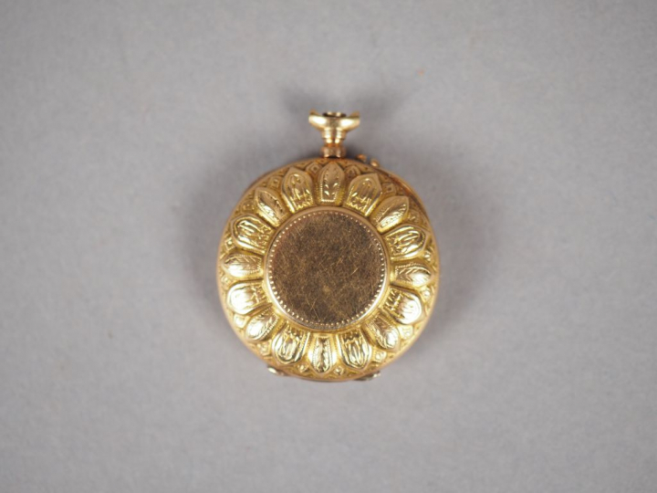 Montre de col en or jaune, à décor de pétales de fleurs.  Cadran émail
