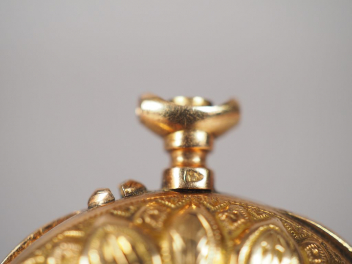 Montre de col en or jaune, à décor de pétales de fleurs.  Cadran émail