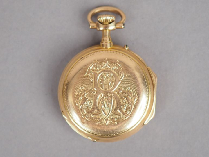 Montre de col en or jaune, cadran émaillé, chiffres romains. Le revers