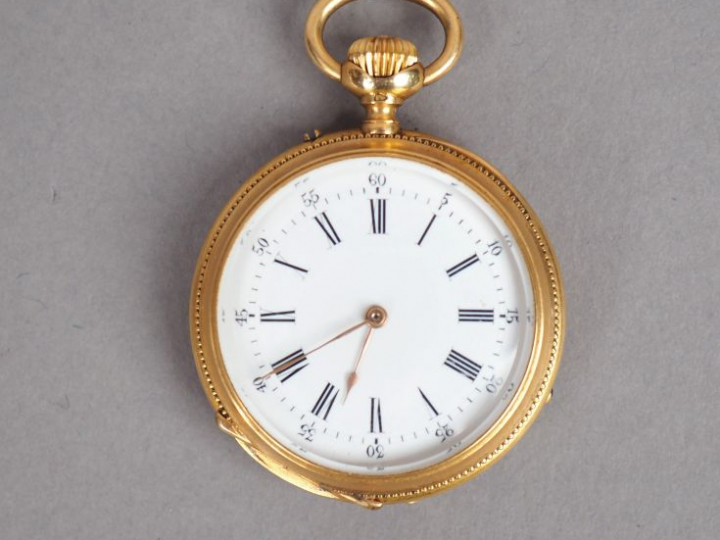 Montre de col en or jaune, cadran émaillé, chiffres romains. Le revers