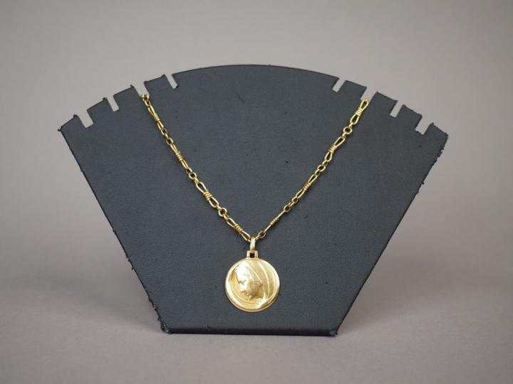 Chaine et médaille en or jaune figurant la Sainte Vierge de profil.  P