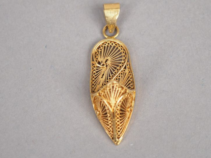 Pendentif en or jaune en forme de babouche, à décor de filigranes. H. 