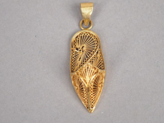 Vente aux enchères Pendentif en or jaune en forme de babouche, à décor de filigranes. H. 