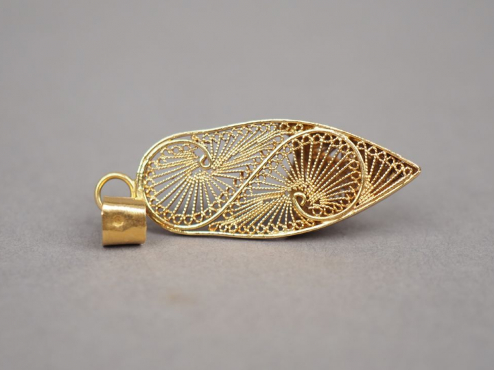 Pendentif en or jaune en forme de babouche, à décor de filigranes. H. 