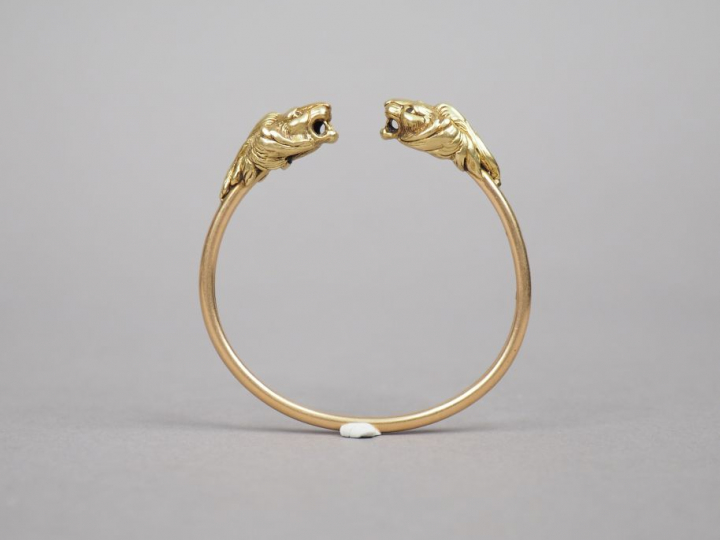 Bracelet jonc en or jaune, à décor de deux têtes de lion.  Poids. 21,7