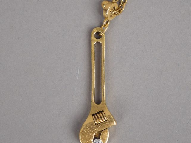 G. JONEMANN Pendentif en or jaune en forme de clé à molette serrant un