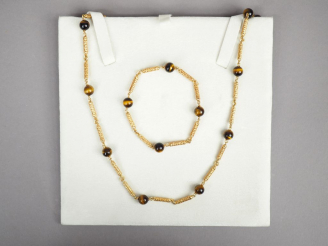 Vente aux enchères Parure en or jaune et perles œil de tigre. Comprenant :  - un bracelet