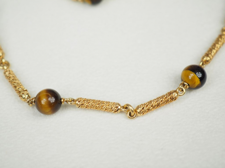 Parure en or jaune et perles œil de tigre. Comprenant :  - un bracelet