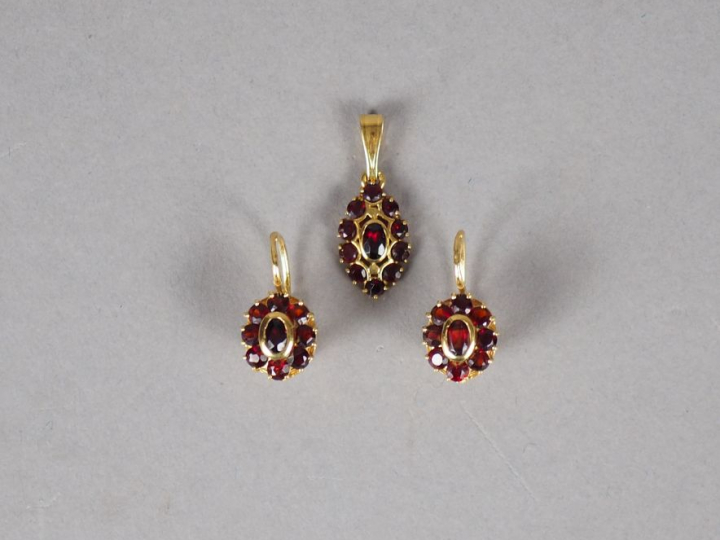 Parure en or jaune et grenats. Comprenant : - une paire de boucles d'o