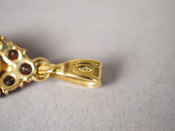 Parure en or jaune et grenats. Comprenant : - une paire de boucles d'o