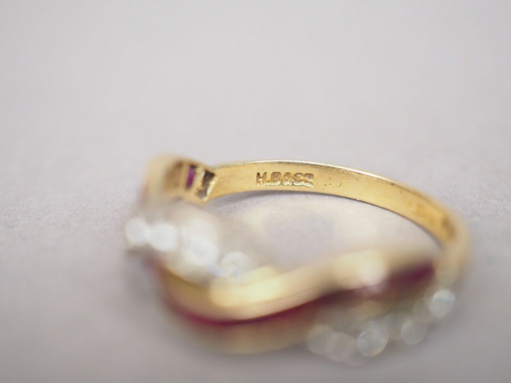 Bague en or jaune, ornée d'une ligne de rubis calibrés entrelacée d'un