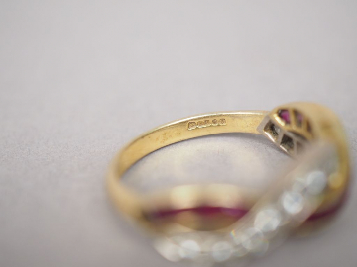 Bague en or jaune, ornée d'une ligne de rubis calibrés entrelacée d'un