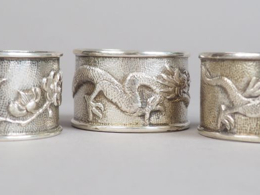 Trois ronds de serviette en argent, à décor de dragons pour deux d'ent