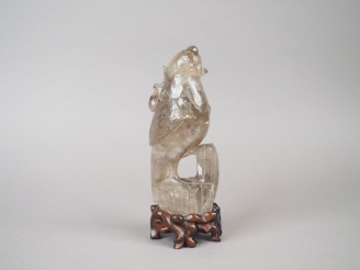 Vente aux enchères Statuette en cristal de roche fumé figurant une perruche posée sur un 